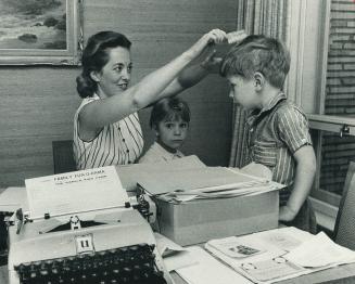 Mrs. Fred Davis tends (briefly) to her motherly duties. But for weeks she's been the harried organizer of tomorrow's Family Fun-O-Rama