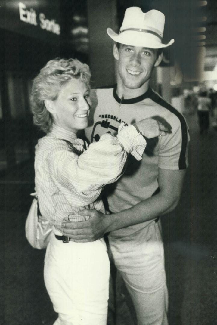 That's my boy: Victor Davis, the world 200 metres breaststroke champion, is hugged by his girlfriend Cheryl Oberle at Toronto International Airport on his return from the world championships