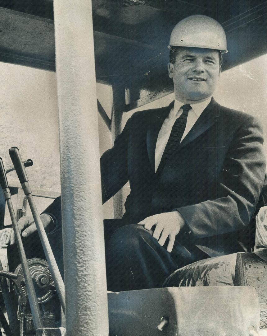 Atop a bulldozer, just two hours after his swearing-in, the new minister makes his first official act at the sod turning of the new Scarborough colleg(...)