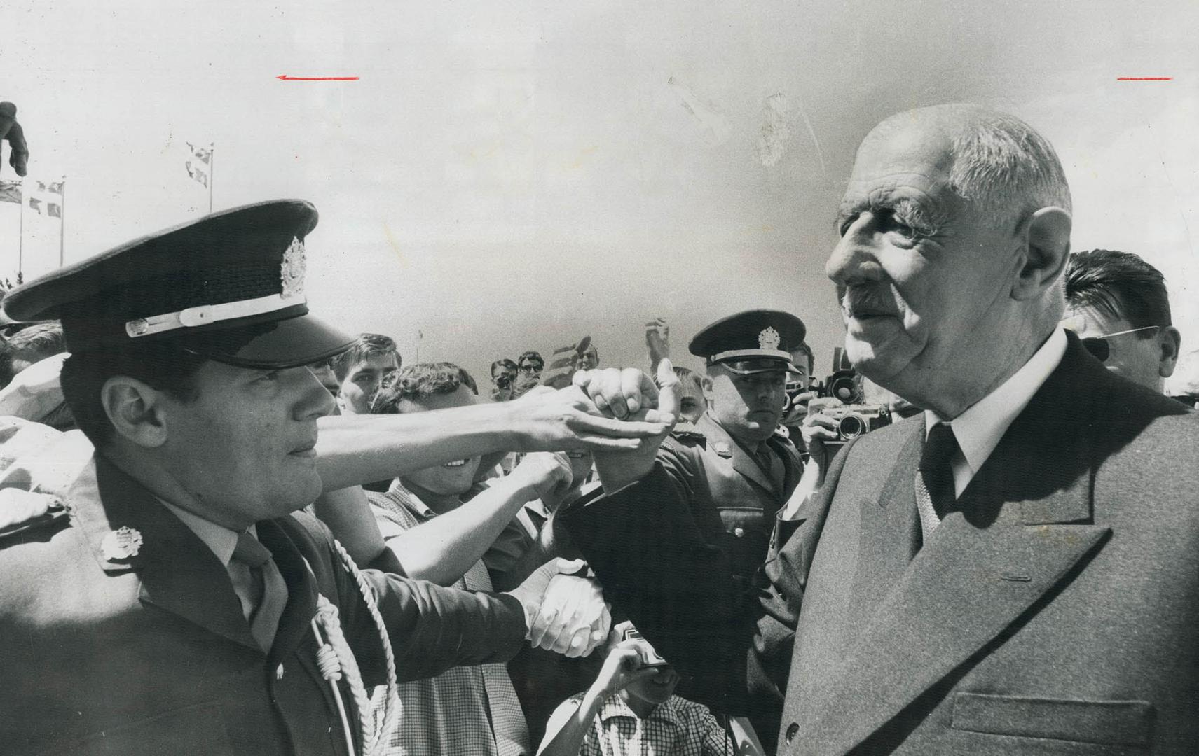 A Ring of Hands surrounds French President Charles De Gaulle during his tour of Expo yesterday