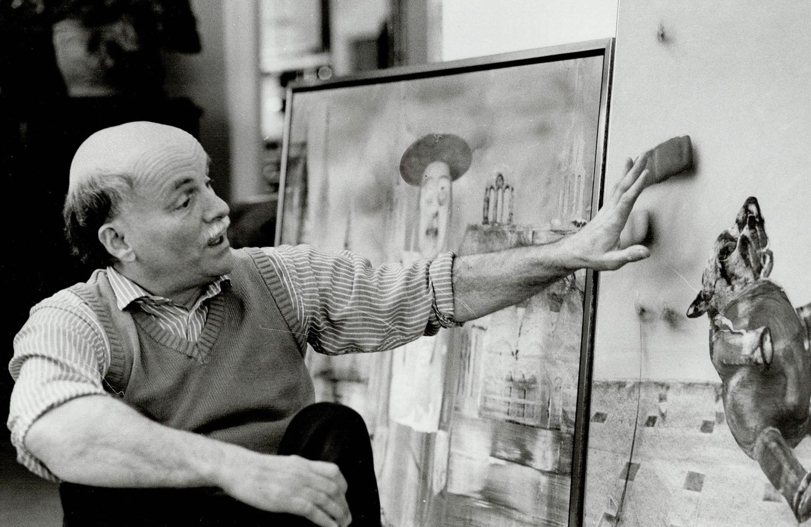 Toronto painter Louis de Niverville sits in front of recent paintings, on the left, Ex Cathedra 2, a collage showing a whimsical cardinal in front of (...)