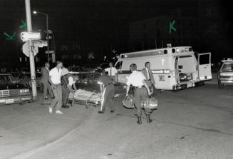 Downtown drama. Police officers and attendants take wounded officer to waiting ambulance that took him to Toronto Western Hospital last night. Police (...)