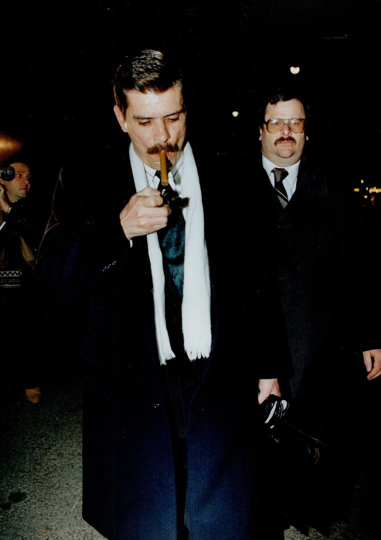 Free man: A relieved Metro police constable David Deviney lights up a cigar yesterday as he leaves court