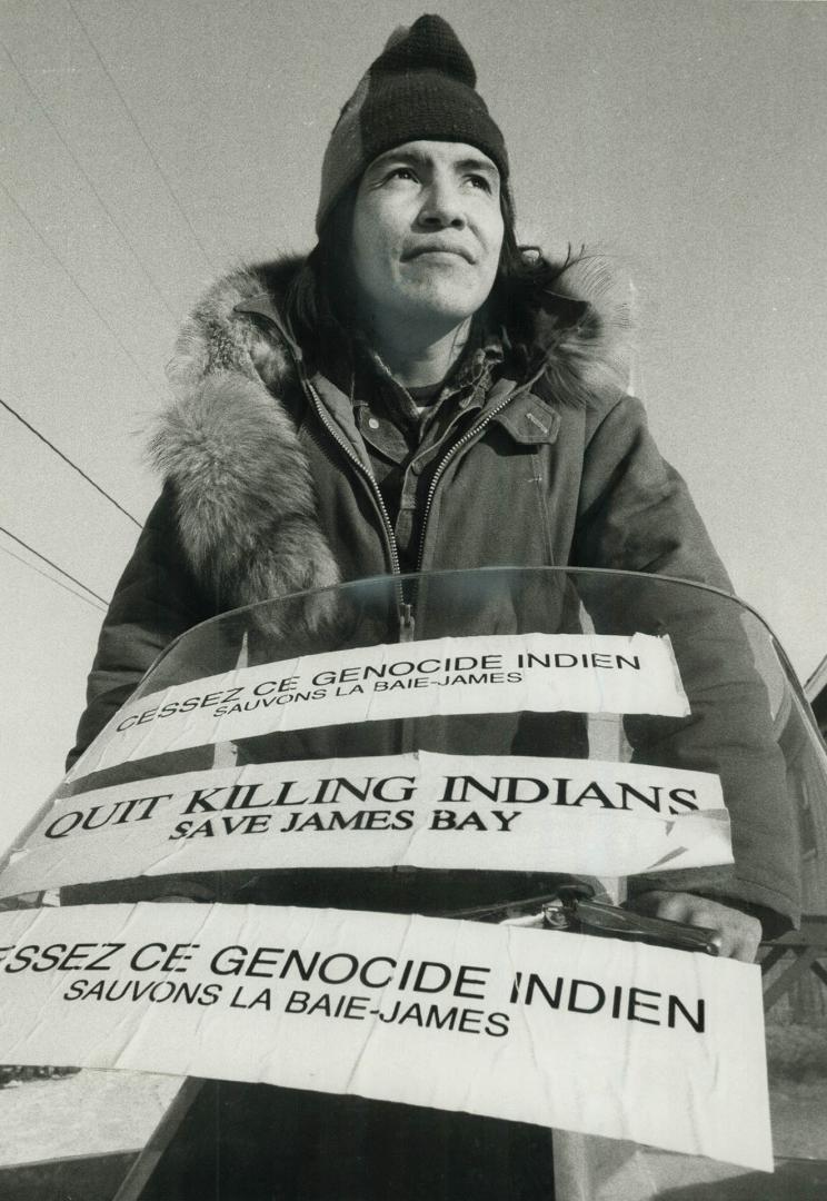 An Indian at Fort George on James Bay uses the windshield of his snowmobile as a travelling billboard