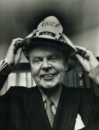 Dief, the chief, tries on fire chief's helmet at a belated birthday party in Minnedosa, Man