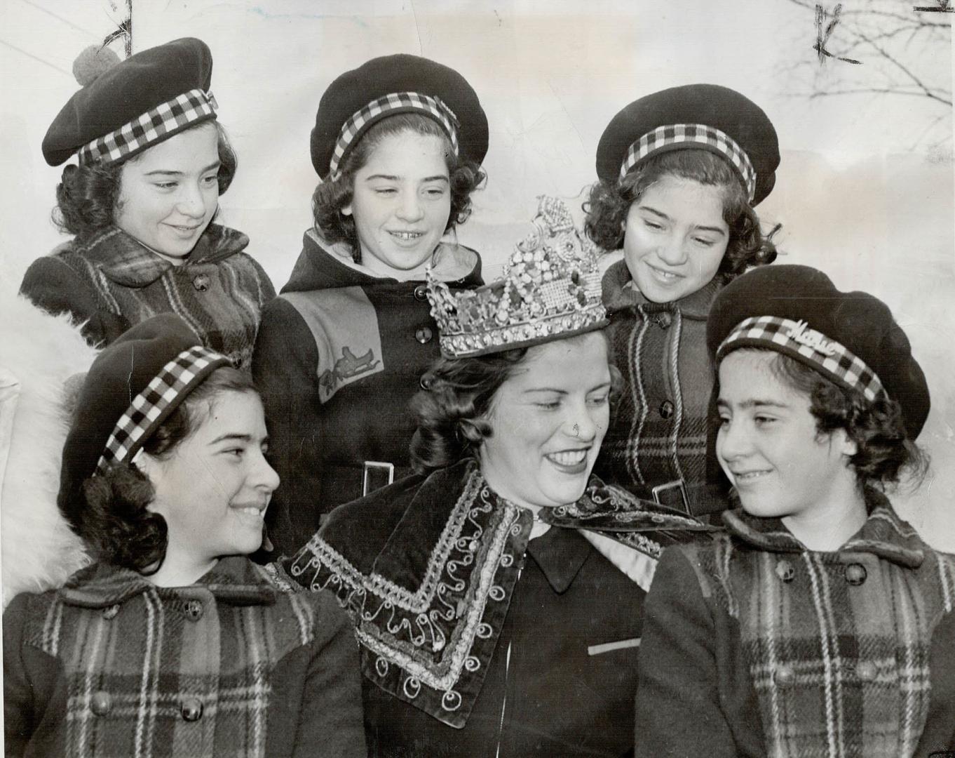 The Dionne Quints in winter garb make an appropriate frame for the crowned queen of the North Bay carnival which drew woodsmen and other outdoor folk from wide areas