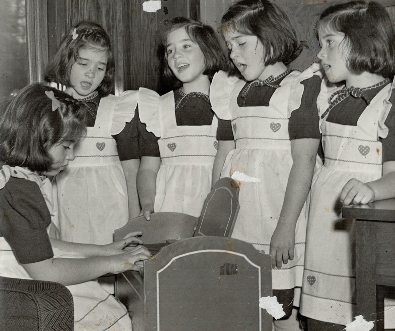 Annette plays the portable organ, and the five famous sisters rehearse some of the songs they will sing at a Victory Loan rally in Maple Leaf Gardens.(...)