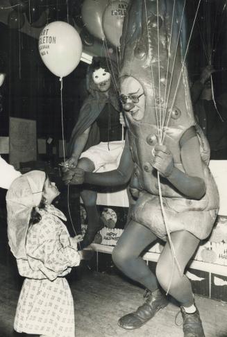 No sourpuss. Dressed as a pickle, but all smiles, Toronto Alderman Art Eggleton hands out a balloon to Diana Russo, 2, of Grace St., at campaign headq(...)