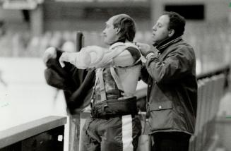 Leaf trainer Arkady Tevlin helps goalie Don Edwards adjust his gear