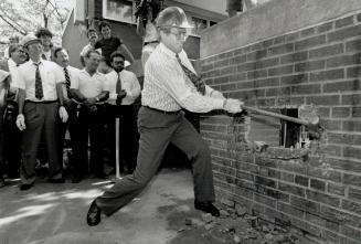 Anti-drug blow: Toronto Mayor Art Eggleton Swings a sledgehammer yesterday to help start demolishing walls at Alexandra Park that residents say conceal drug deals in the neighborhood