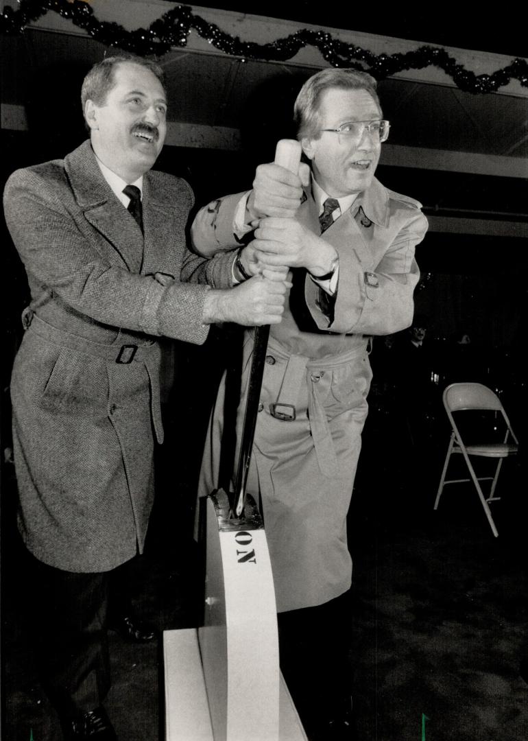 It's light-up time. Gary Lehman, head of Electrical Contractors of Toronto, left, and Mayor Art Eggleton pull huge switch to turn on Christmas lights at Nathan Phillips Square last night