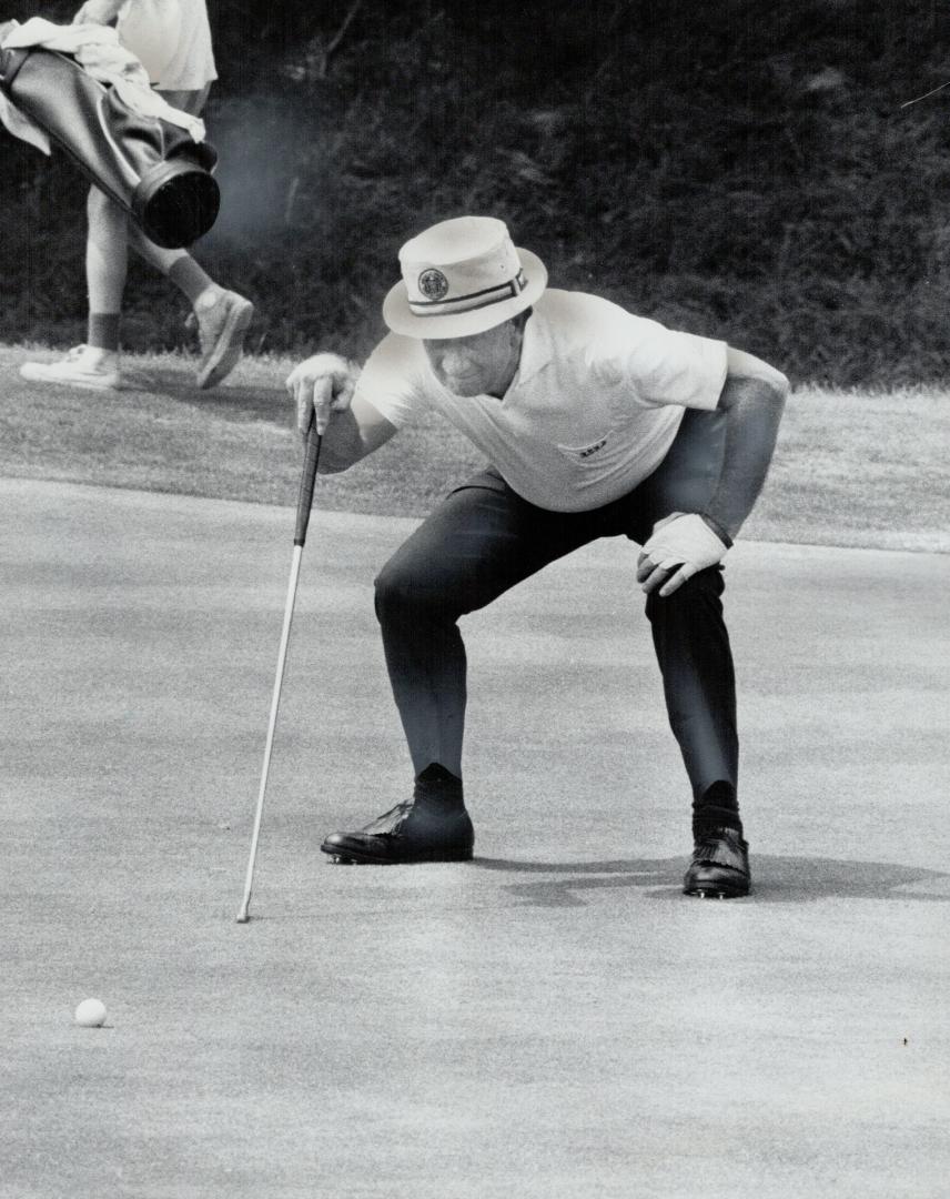 Phil Farley of Scarboro coaxes a putt down during yesterday's first round of the Canadian seniors golf championship