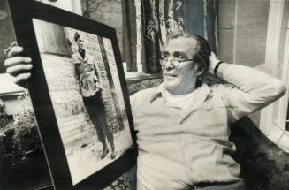 Former spitfire pilot C. Wallace Floody, who was shot down in 1941, holds picture of himself taken in a German war-prisoner camp