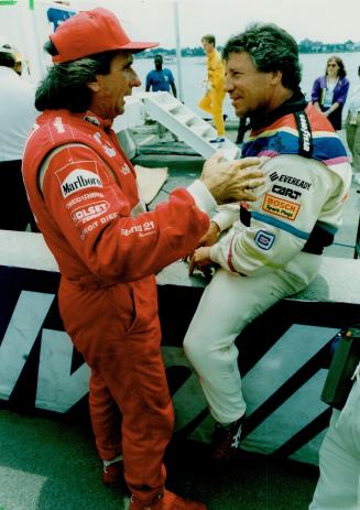 Former F1 titlists Emerson Fittipaldi and Mario Andretti (top) pass the time on Detroit pit row