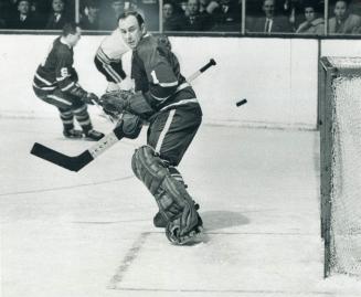 Bruce Gamble begins to spin around and off his feet after puck ripped between elbow and body, en route to net