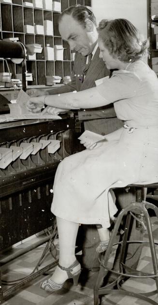 Dr. Gallup looks over one of the mechanical counting machines used in the task of tabulating opinions. He has kept a careful check on American war att(...)