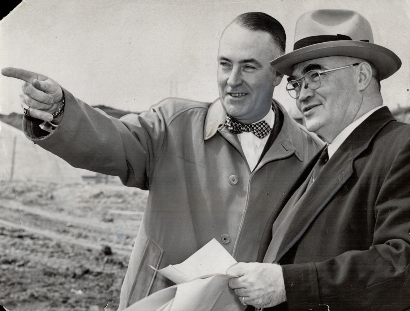 Reeve Bev. Lewis of Etobicoke and Chairman Gardiner discuss possibility of new bridge at western entracne to city as the tour continuous. It was point(...)