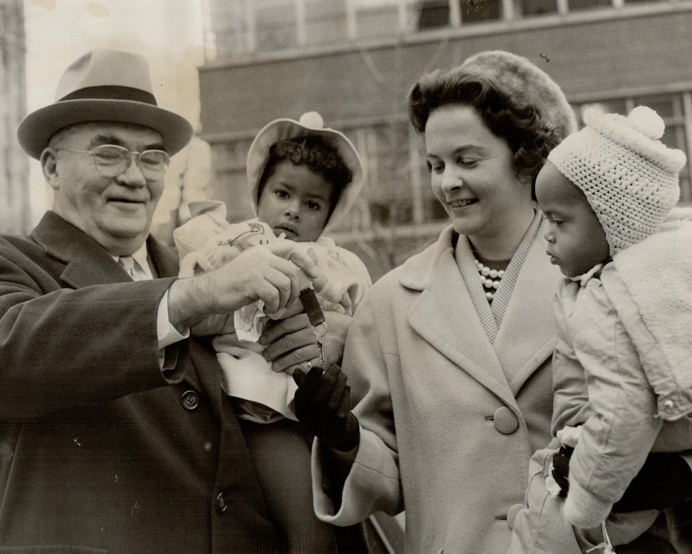 Big Daddy holds baby. Metro Chairman Fred Gardiner (holding Mary Ann) turns over keys to car, presented him by Downtown Business Men's Association to (...)