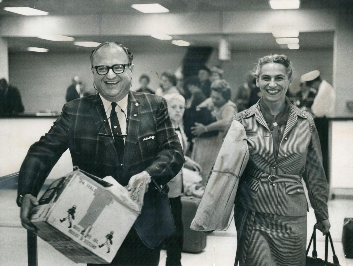 Mayor Givens Totes gifts as he and wife arrive at Malton from Europe