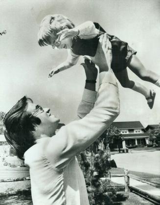 Metro Chairman Paul Godfrey throws his 3-year-old son Robin into the air at the home in Don Mills