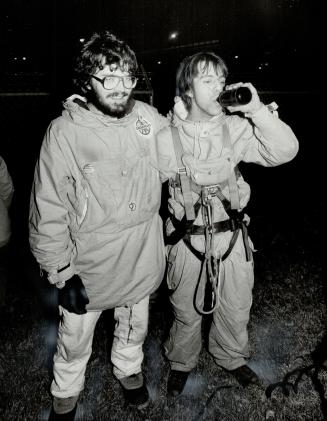 First the beer: Greenpeace protester John Willis, 19, was lured down from his smokestack perch by the offer of a cold beer and a hot shower