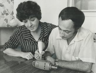 Metro insurance agent Terry Welbanks, left, observes while client Clyde Carson tries out new general insurance tool-a vibrating engraving pencil. The (...)