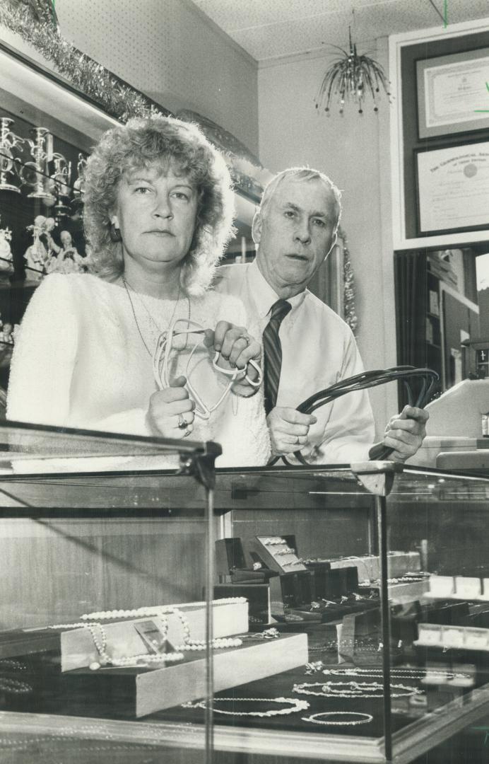 Tied up: Employee Sylvia Dignard and jeweller Ed Green show the cords that were used yesterday to tie them up in a robbery at Green's store