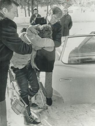 Accused Kidnapper Wayne Lockhart, 22, is helped from wheelchair into police cruiser by Det