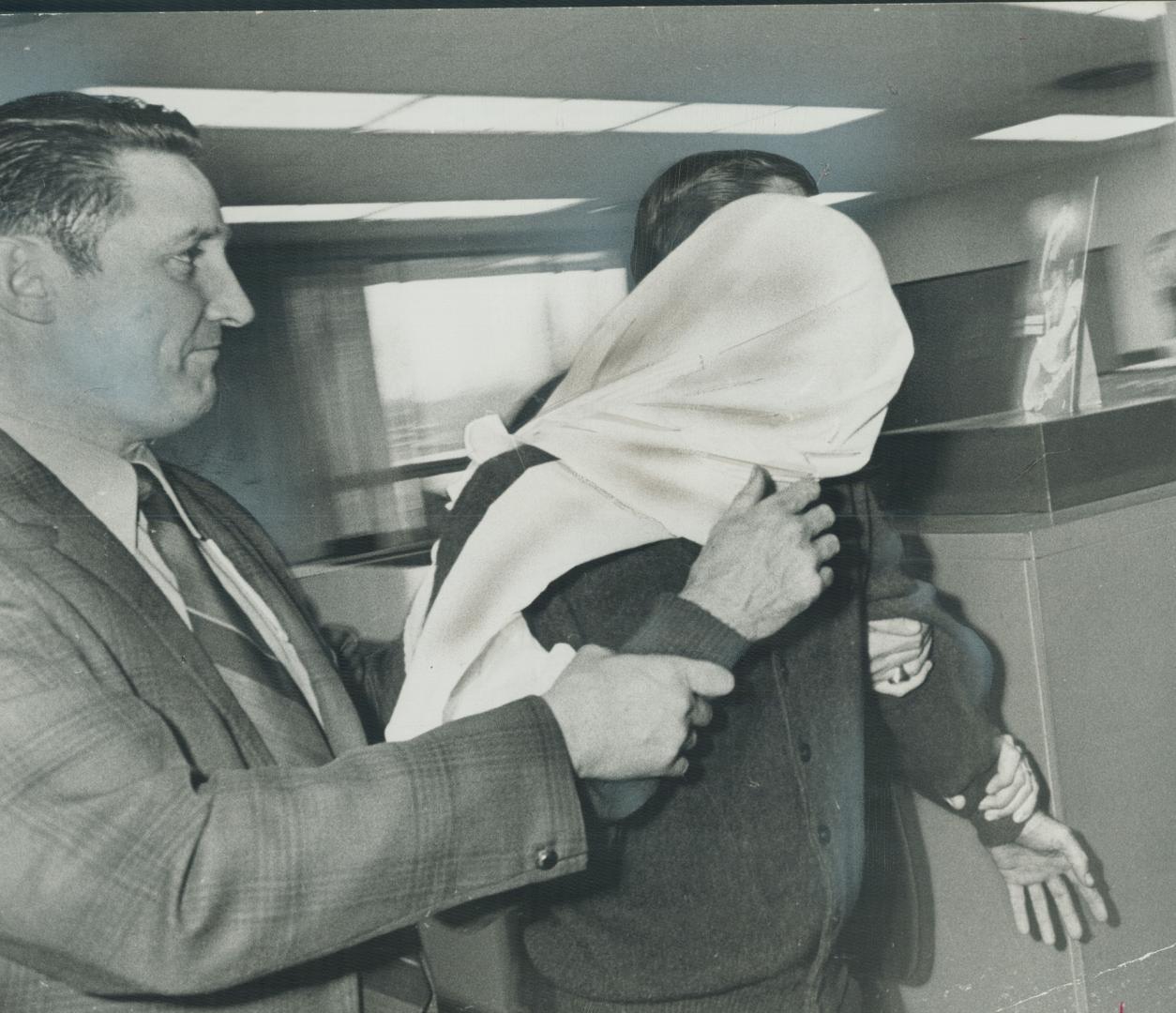 Shooting suspect is escorted to cells by police officer after a shoot-out in Scarborough following a bank robbery yesterday. Three police constables a(...)