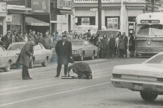 Metro bomb squad members cautiously look over suspected bomb as police photographer takes photos