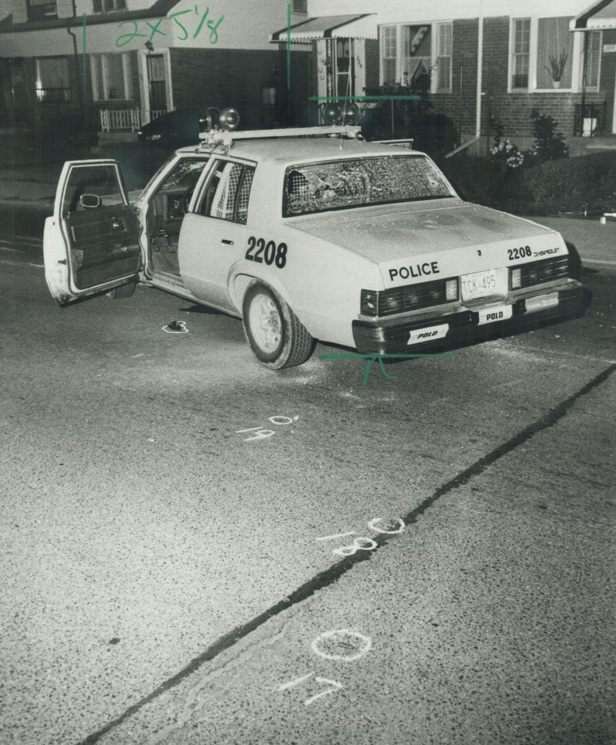 Officer's gun: A policeman's gun lies on the ground outside the open door of the car that pulled over the gunman