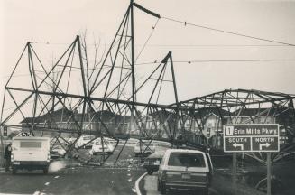 Toppled Tower: Hydro crew inspects crumbled transmission tower blocking the Erin Mills Parkway in Mississauga