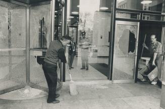 Vandal Smashes Courthouse Windows, Workers sweep up glass at the University Ave