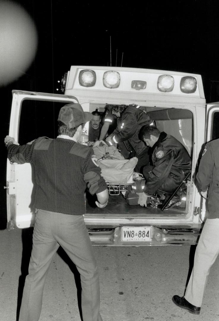 Gunned down: Ambulance attendants work to save the life of Garfield Blackwood, critically shot last night at his Etobicoke home