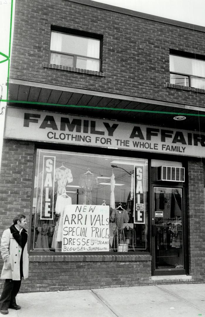 May close: The father of clerk Marisa Boscaglia stands in front of Family Affair clothing, hit by $20,000 robbery yesterday