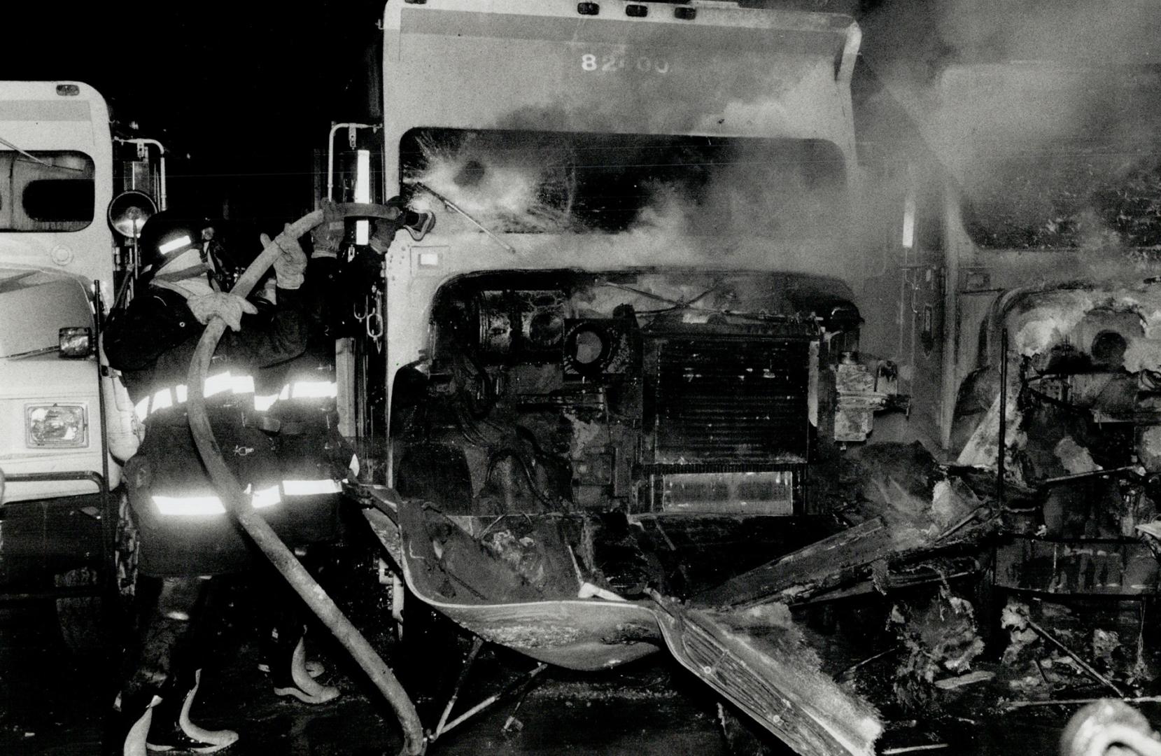 Brink's trucks torched, Firefighters pour water on to one of four Brink's trucks set on fire in the company's east-end yard early yesterday