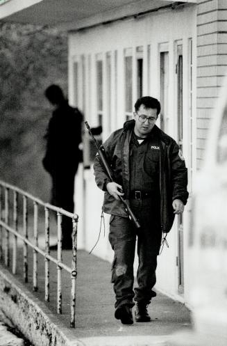 Police under fire: A police officer keeps vehicle between himself and the Rainbow Motel on Lake Shore Blvd