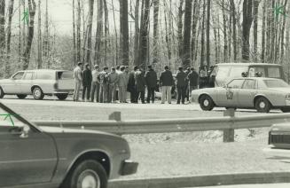 Death scene: Peel police and law enforcement students watch as the budgeoned bodies of Berna Miller, 41, and her daughter, Lisa Lloyd, 14, are removed from their car in Mississauga