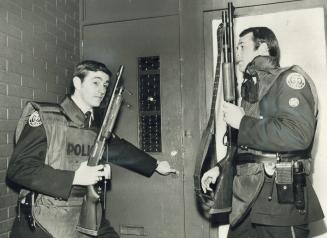 Emergency task force police, armed with shotguns and wearing bullet-proof vests, prepare to storm an apartment on Dundas St. E. early this morning aft(...)