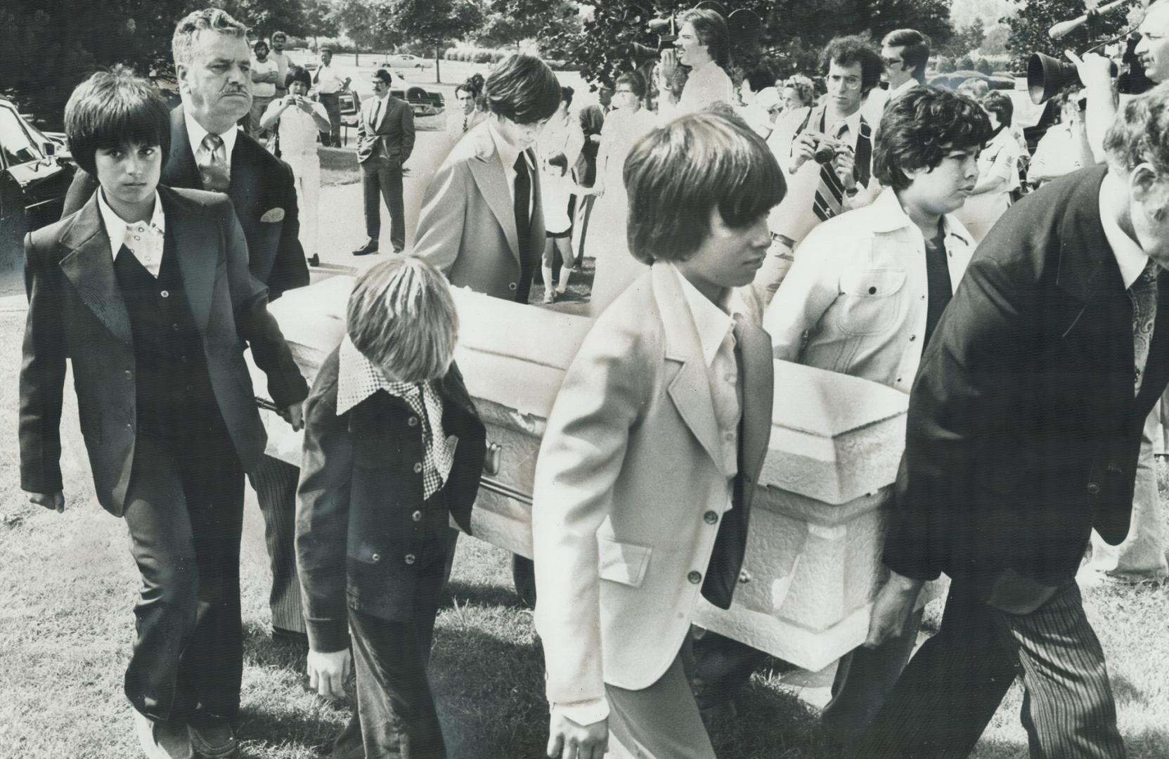 Young friends of Emanuel Jaques carry his white coffin to graveside