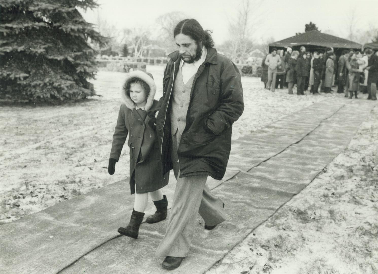 Grieving family: Brendan Caron, father of slain Sharin' Keenan, walks away from her grave yesterday with his daughter, Celeste, 6