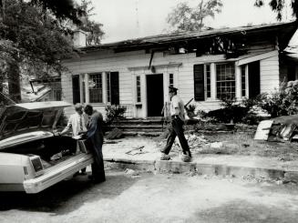 Fire scene: Police and fire marshal's investigators probe the fire gutted home of Peter Demeter after the house was hit Tuesday by the third blaze in eight days