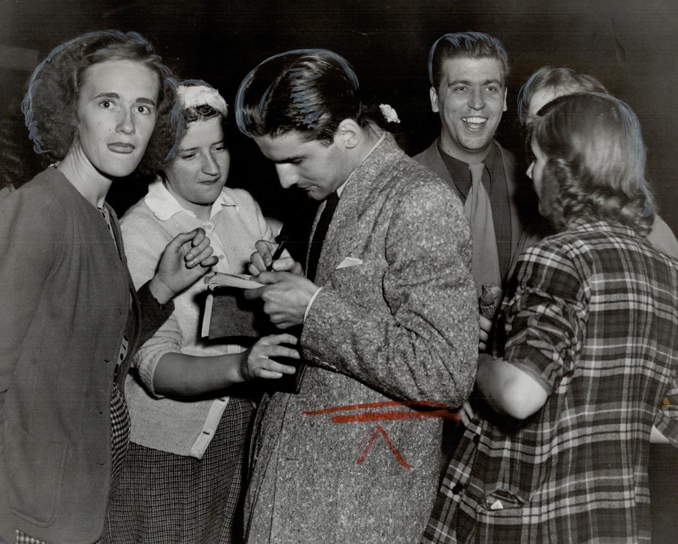 Eager spectators, mostly bobby-soxers, are seen getting autographs from Kettlewell and Barrie