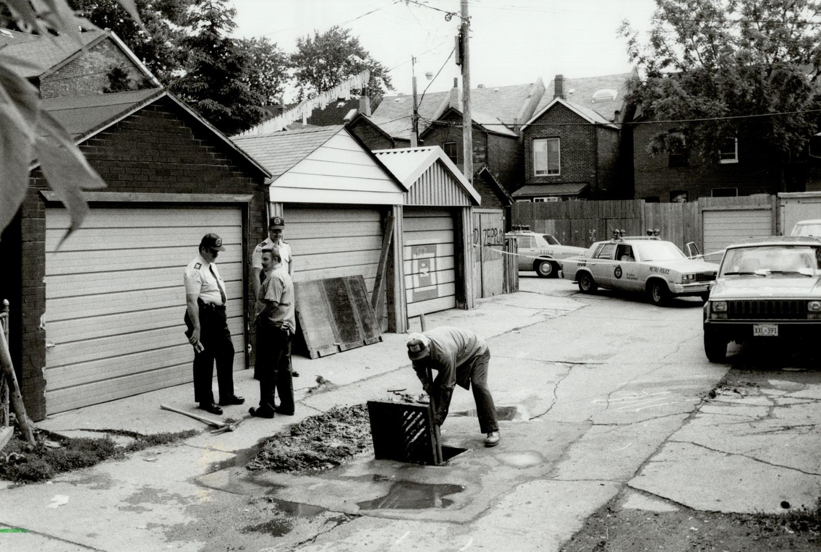 Murder scene: While a Parkdale alley sewer is searched for the knife that killed Nelson Machado, 16, police look for other clues