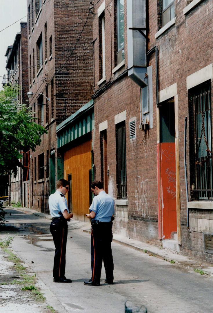 Site of slaying: Police consult outside building near where broadcaster was shot as his wife watched