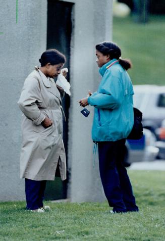 In shock: A neighbor, left, stands weeping at the scene with a friend