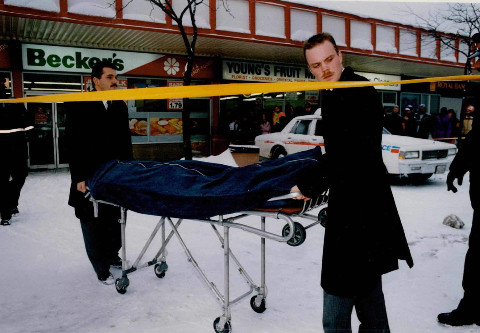 The body of murdered store clerk Horacio (Ross) Diogo, 27, is removed from Becker's milk store where he was shot last month during a robbery that was filmed on the store's surveillance video