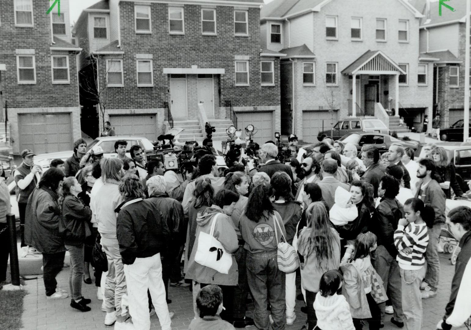 Officer explains: Residents and reporters surround police officer Ed Hill as he explains that the body discovered in the building has not been positively identified as Andrea