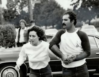 Shocked sister: Bonnie Romanelli, sister of Charles Boyd, is led away by her husband at the scene of the shootings that claimed the life of her brother and his friend Terri Lukow