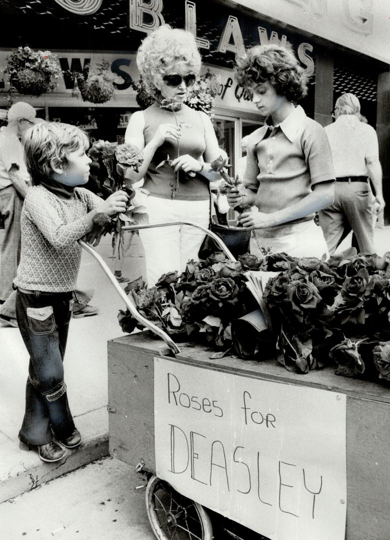 Two friends of Kirkland Deasley, who was found strangled and mutilated in a downtown hotel last week, sell roses to help his mother. Brian Sills, 7, a(...)